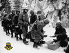 Here is the Army Signal Corps Official Photo  of I-347...

The caption reads:
"On the way to LaRoche"

This is "I" Company of the 347th Infantry.
Actually the Group did not get to La Roche, but entered fighting in the 
Ardennes at Moircy, Belgium. 
Shown receiving food in his mess kit is John Olson of Arlington Hieghts, IL.
He is the immediate Past Commander of the 87th Infantry Division Association.
These men just received the newly isssued galoshes seen over their combat boots. 
Mal Grant placed the 347th Regimental Crest in the lower corner.

submitted by John McAuliffe; M-347
===============
This is letter sent to Army HQ by John McAuliffe
describing photo and giving information about it:

Dear Sirs:
For your information I have enclosed the famous and popular photo found in most Army History books related to the 'Battle of the Bulge'....Unfortunately most books do not give credit to the photo and identify it. The photo is of I-Company, 347th Inf.; 87th Inf. Div. It is an Army Siganl Corps photo with the caption,
"On the road to La Roche".....Unfortunately the unit did not go to La Roche but went into action in January 1945at Moircy,Tillet, Bonnerue in Belgium. The unit arrives here to get the new issue of galoshes as seen in the photo. The soldier with carbine over shoulder receiving his portion is John Olson of Arlington Heights, ILL and still lives there. Other soldiers are identified. Tom Hewlet with the forlorn eyes died early after the war, but his son Tom Hewlett and wife Pat attend the 87th Div. Assoc. Reunions as does Olson and his wife.The Company Commander of I-Company, 347 Inf. was and still is Captain Ray E.Miles, who lives in Richmond, VA.
I am sending you this information for your observation and possiblity for your Headquarters to properly identify this photo for posterity.
My qualifications are that I am a former member of M-347; 87th Inf. Div WW-II. I am the Past Commander of the 87th Inf. Div. Association; I am current Vice Pres. of Chapters for the National Veterans of the Battle of the Bulge Inc; I am current Pres. of the Cent. Mass. Chapt.-22;VBOB....
This photo tells a lot; Just look at it ; examine it and from the clothing and the surrounding snow draped fir trees, one may get an inkling of what it was like in the ARDENNES CAMPAIGN during WW-II.
Best Regards,
John E. McAuliffe
==============

Posted comment:
" Included in this potograph is my grandfather, William Corriveau, back row looking to the left with his face covered and the BAR hanging on his shoulder. As I understand it, this was his squad. I too have an original DOD print of this picture that sits proudly in my office."

 Daniel Corriveau
===============

Posted Comment :
 John W. Olson.(Obituary)
Daily Herald (Arlington Heights, IL), April, 2003 
John W. Olson of Rolling Meadows Services for John W. Olson, 83, will be held at 11 a.m. Friday, at Matz Funeral Home, 410 E. Rand Road, Mount Prospect. Born Sept. 2, 1919, in Chicago, he died Tuesday, April 8, 2003, at home. Interment will be private. Mr. Olson was a retired cable splicer for Commonwealth Edison. He was a World War II Army veteran. He was the beloved husband of the late Rita.

======================

This photo can be found in many WWII books.  
It was the first photo I put in our family tribute book about our Uncle Mel.
To discover that he served in the 87th Infantry Division, and now to know this photo is of men from the same Division, makes the photo a very emotional one for me.  

As with all galleries of history06 - 
we welcome comments/thoughts/memories.
Just click on the "comment" in 
lower left of page.

Here's to the Golden Acorn Soldiers - Forever STALWART AND STRONG!

For info on 87th Infantry Division Association:
http://www.87thinfantrydivision.com